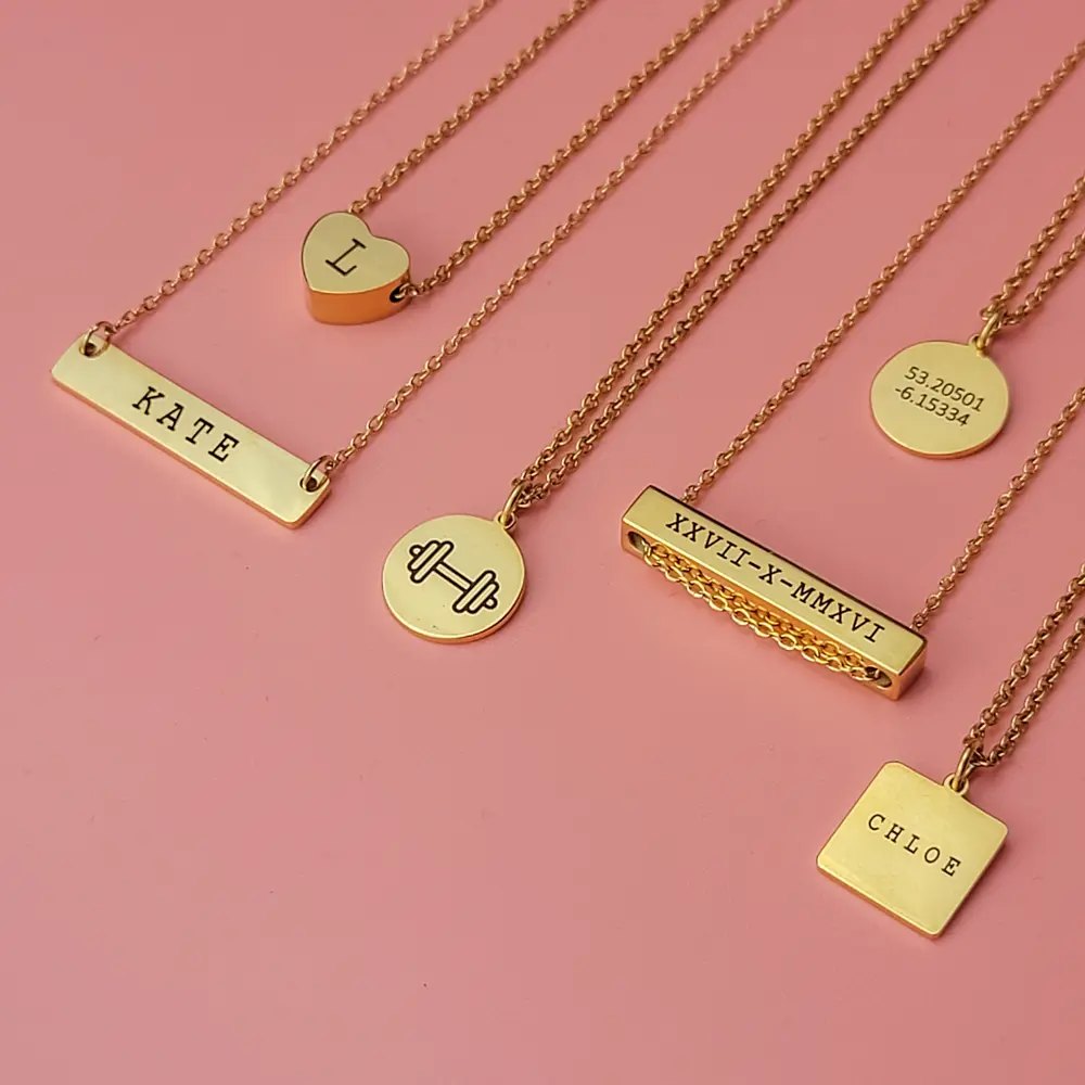 A collection of Lovebomb personalised necklaces on a pink background